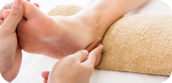 Massage réflexologie avec un bâton en pierre minéralr