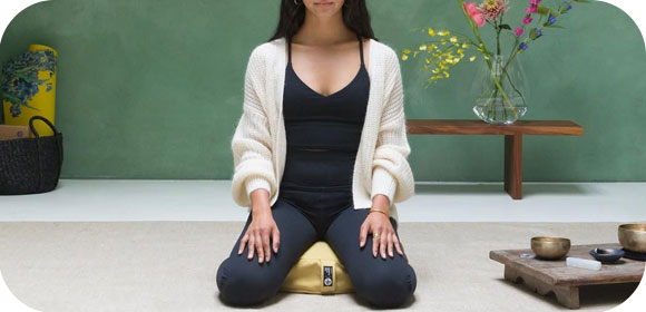 Femme assis sur un coussin de méditation