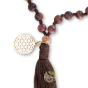 Détail pompon et fleur de vie en plaqué or sur Mala oeil de taureau et bois de santal