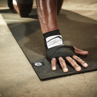 Une main posée sur un tapis Manduka X